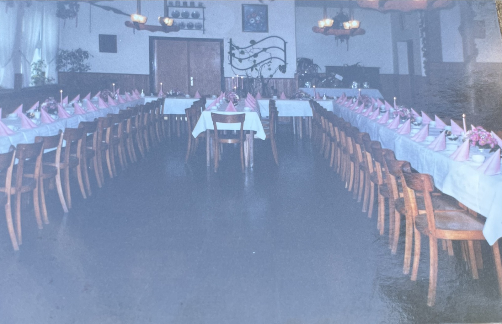 Lange Tafeln im Saal, bereit für Gäste